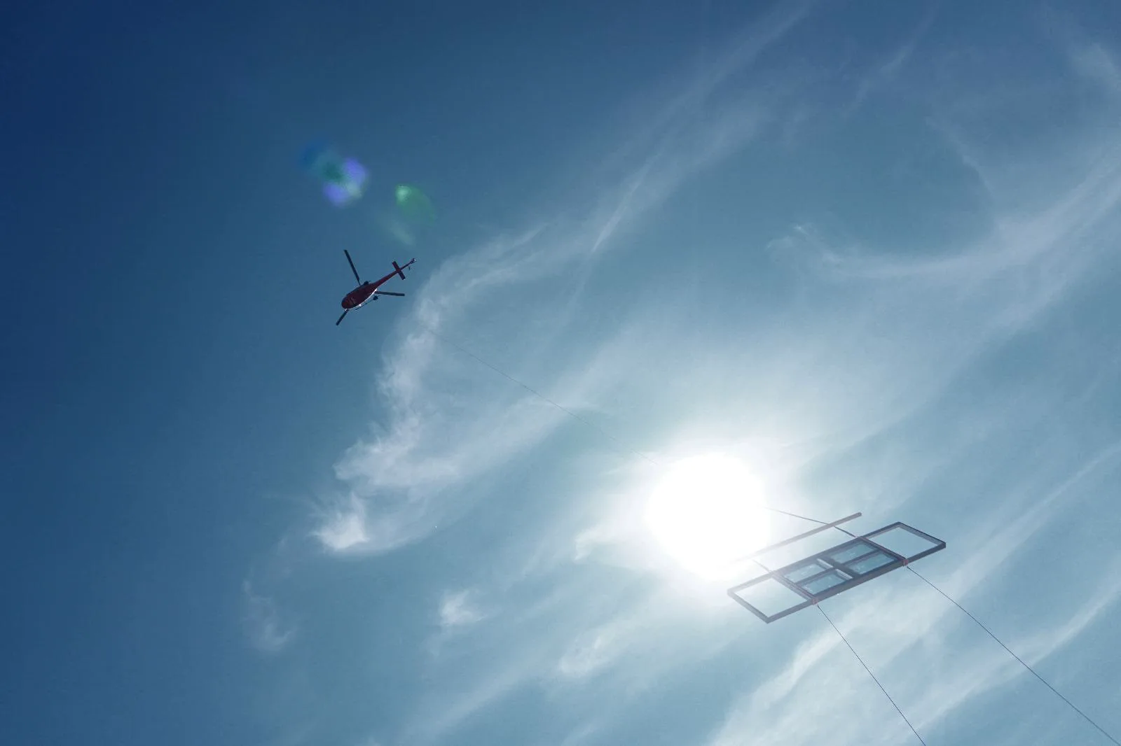 Grosses Glaselement bei der Montage mit einem Helikopter