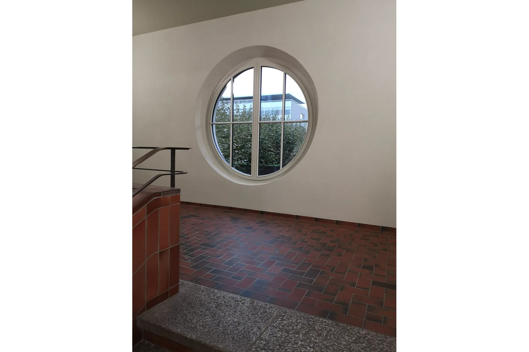 Rundes historisches Fenster in einem Treppenhaus